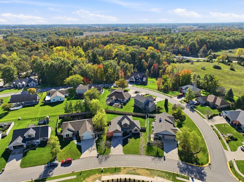 Drone photo of a wooded residential neighborhood in early fall