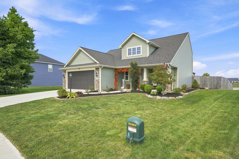 Craftsman-style home with stone accents and a deep green front lawn
