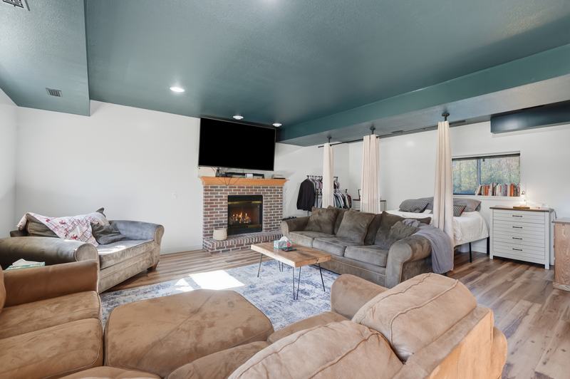 Finished lower-level family room with a stone fireplace and sectional sofa