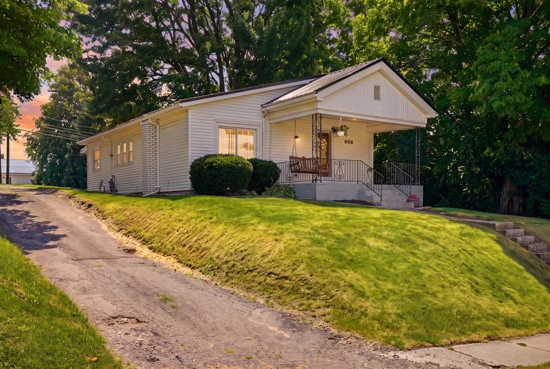 Craftsman cottage with front porch at dusk under a soft pink sky